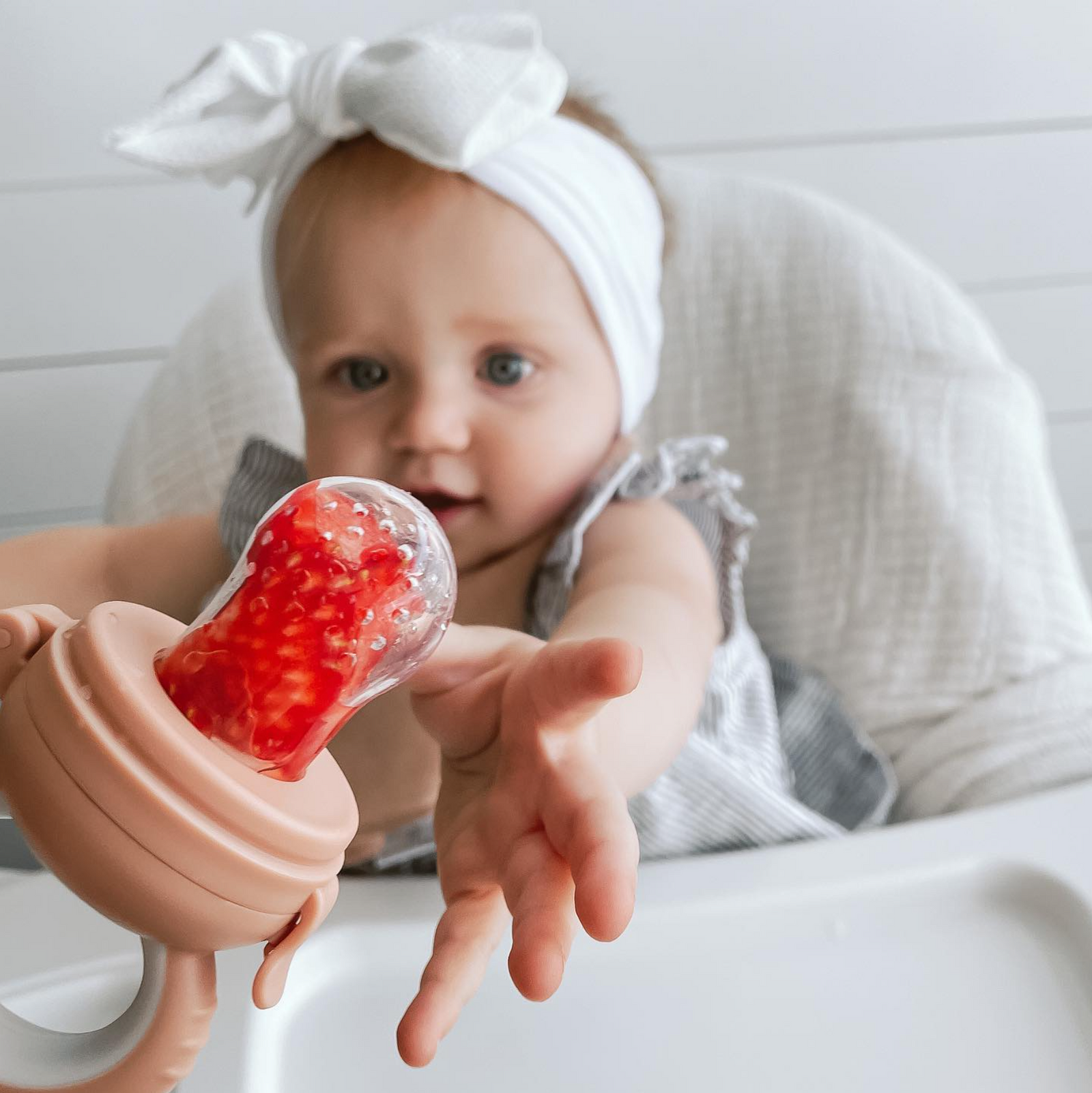 Frozen fruit in silicone mesh teether for soothing sore gums